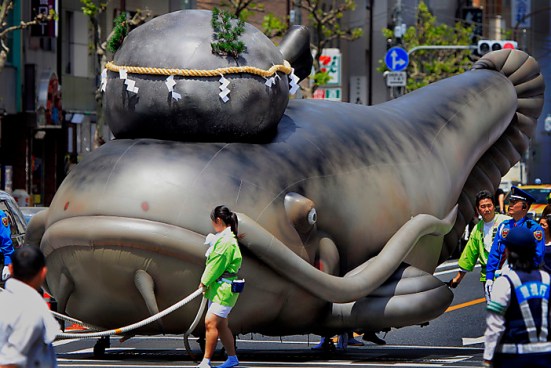 A float in the shape of a giant catfish with a large stone placed on its head is drawn by festival goers during the annual Kanda  Myojin Festival parade in Tokyo Sunday, May 9, 2010. The fish is locally known as the symbol of earthquakes and the sacred keystone is believed to contain the power of temblors.(AP Photo/Itsuo Inouye)